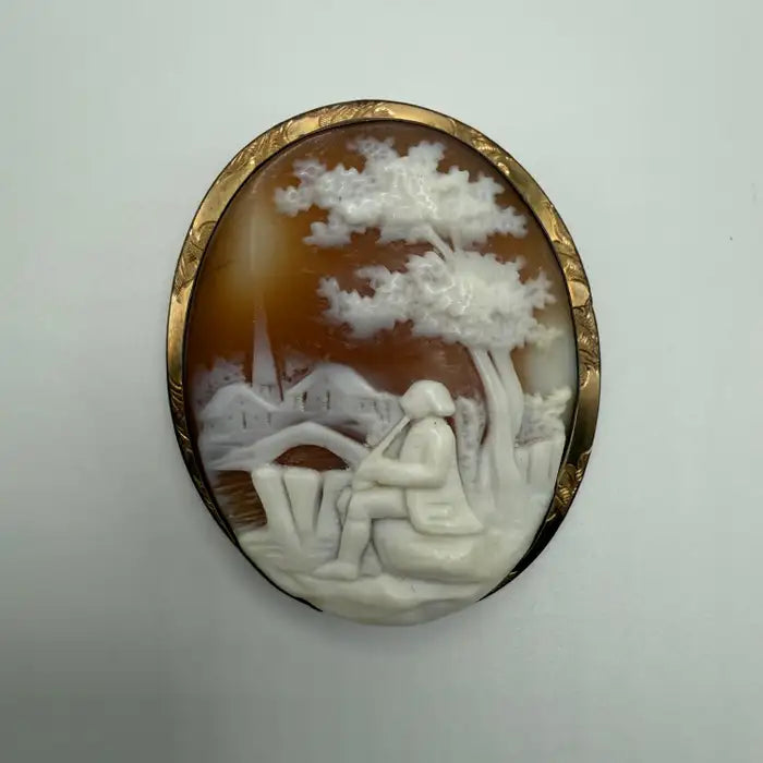 Victorian Shell Cameo Brooch Featuring Seated Flutist, Tree, and Bridge in Pastoral Scene, Late 19th Century