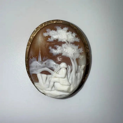 Victorian Shell Cameo Brooch Featuring Seated Flutist, Tree, and Bridge in Pastoral Scene, Late 19th Century